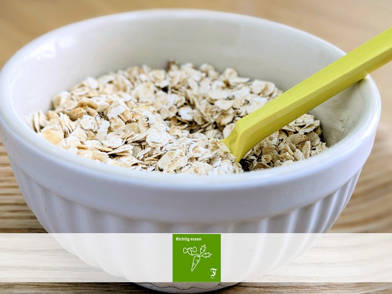 Haferflocken in Schüssel mit Löffel Haferflocken in Schüssel mit Löffel